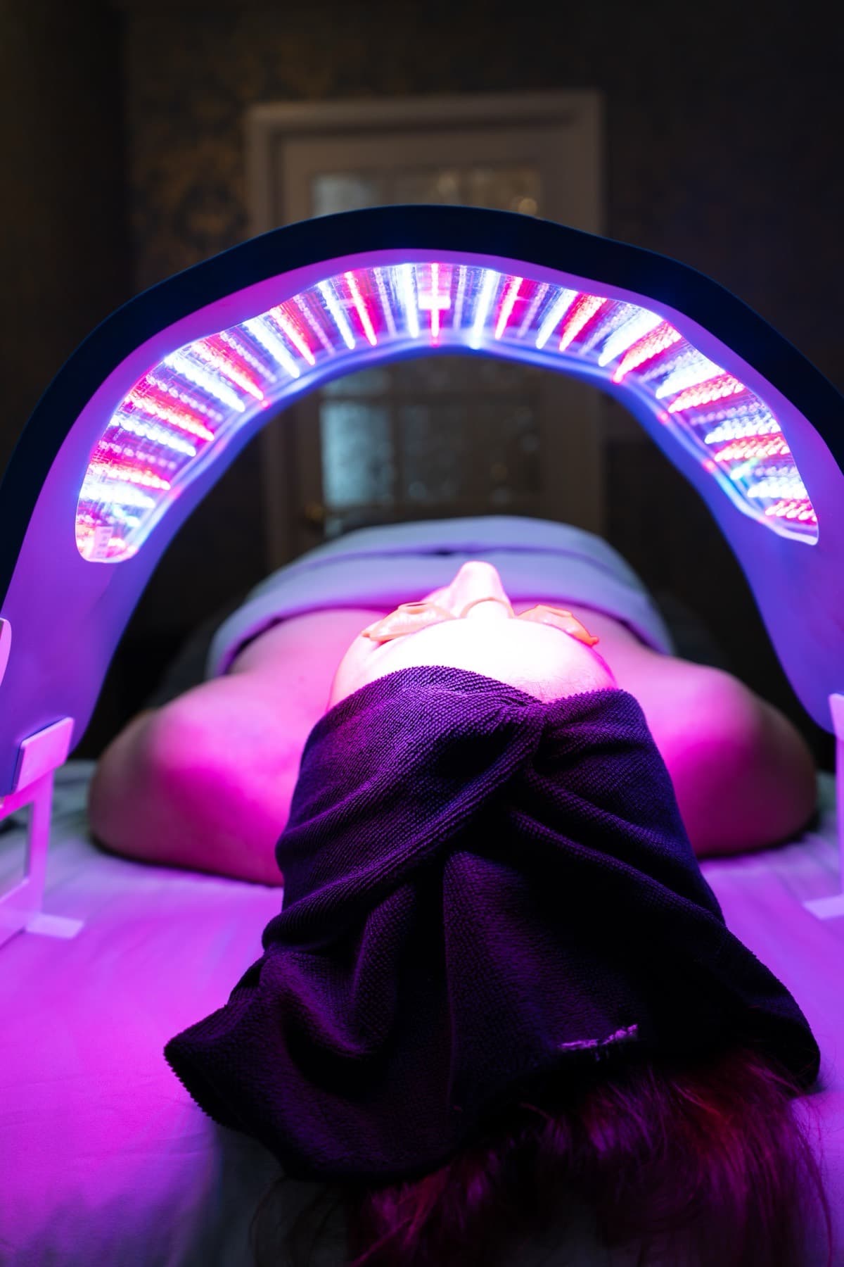 Guest under an LED light therapy canopy during a facial at LNO Boutique med spa in Centennial, Denver