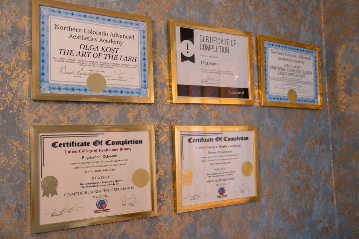 Framed licenses and certifications of the LNO Boutique team on the wall in Centennial, CO