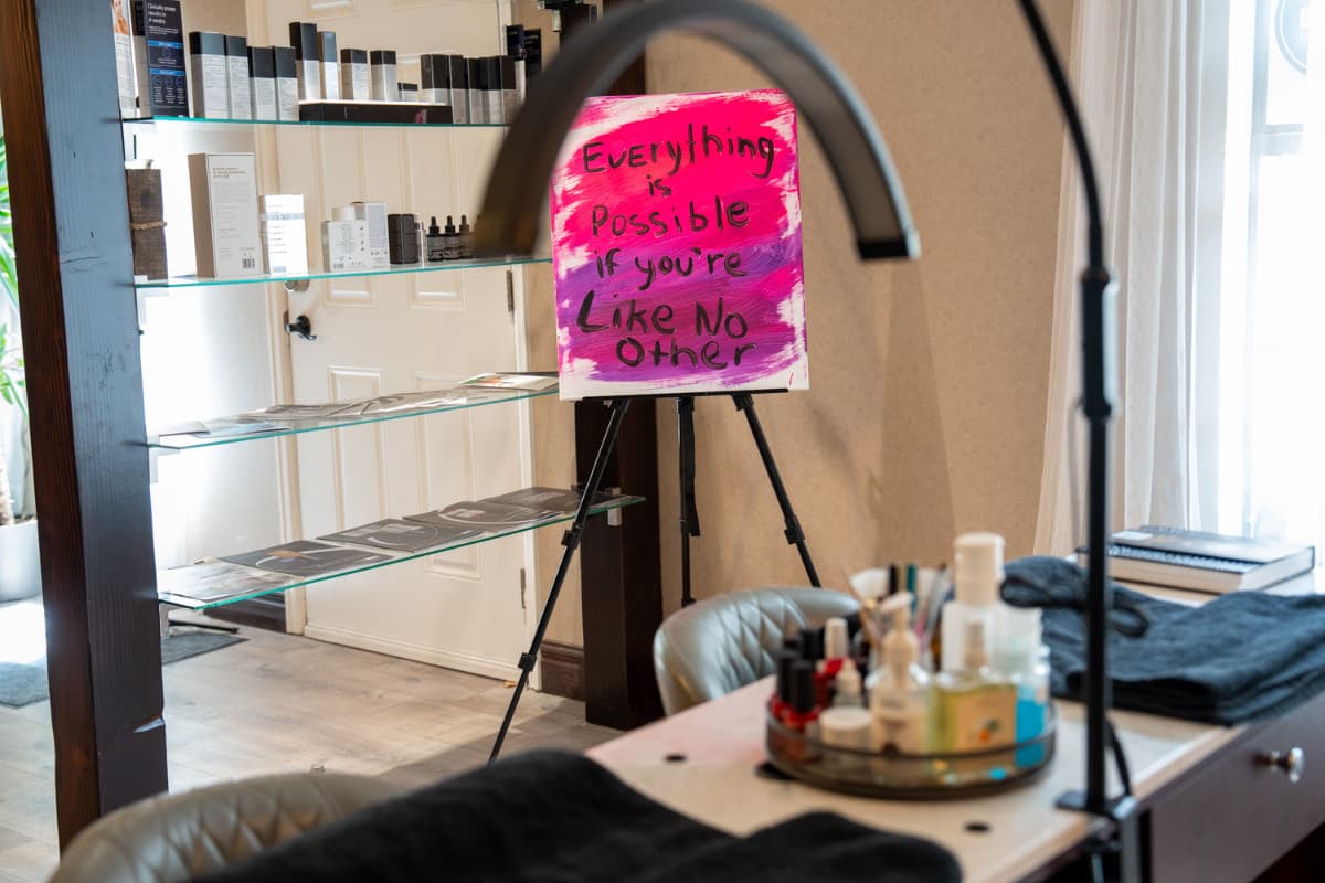 Med spa treatment room with the 'Everything is possible if you're Like No Other' sign at LNO Boutique in Centennial